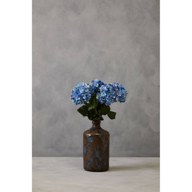Decorative vase with blue flowers against a gray background