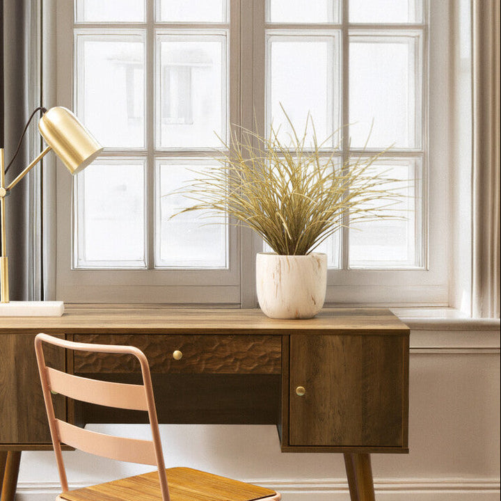 Wooden desk with chair in a room with large windows and curtains.