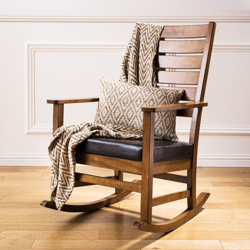 Wooden rocking chair with cushions and a blanket on a wooden floor.