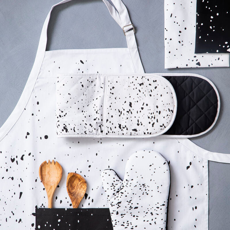 Speckled apron with oven mitt and pot holder on a gray background