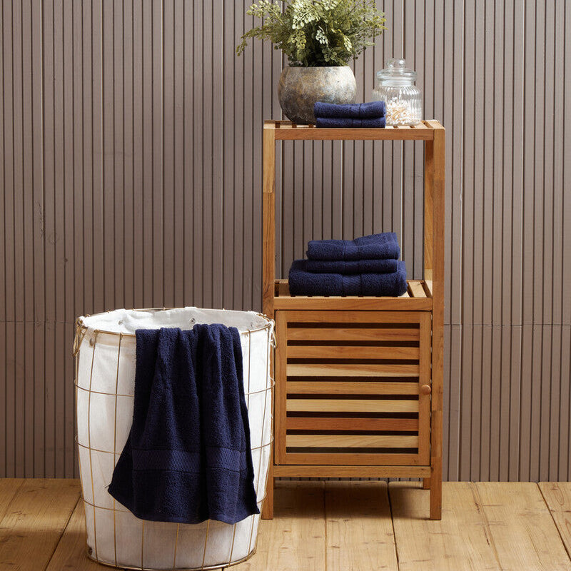 Towel rack with folded towels and a plant against a striped wall.