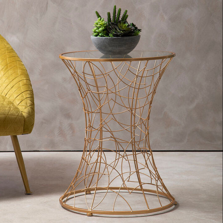 Gold wire side table with a plant on a gray background