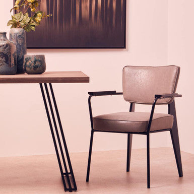 Modern chair next to a wooden table with decorative items in a minimalistic setting.