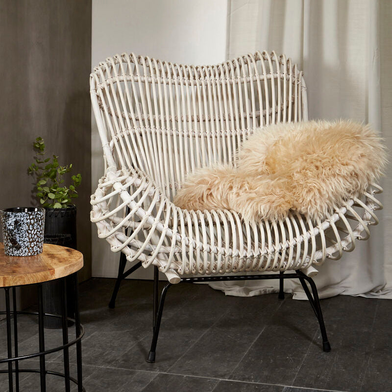 Wicker chair with a fluffy cushion in a room setting