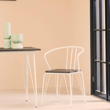 White chair and table against a beige wall with a window on the right.