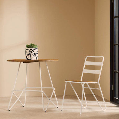 Wooden table with a white chair against a beige wall
