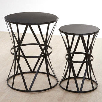 Two black metal side tables on a wooden floor.