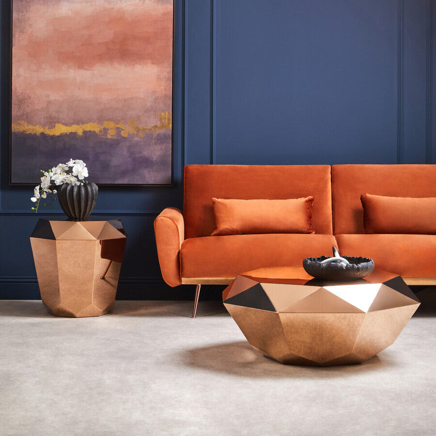 Modern living room with orange sofa, geometric coffee table, and abstract painting on a blue wall.