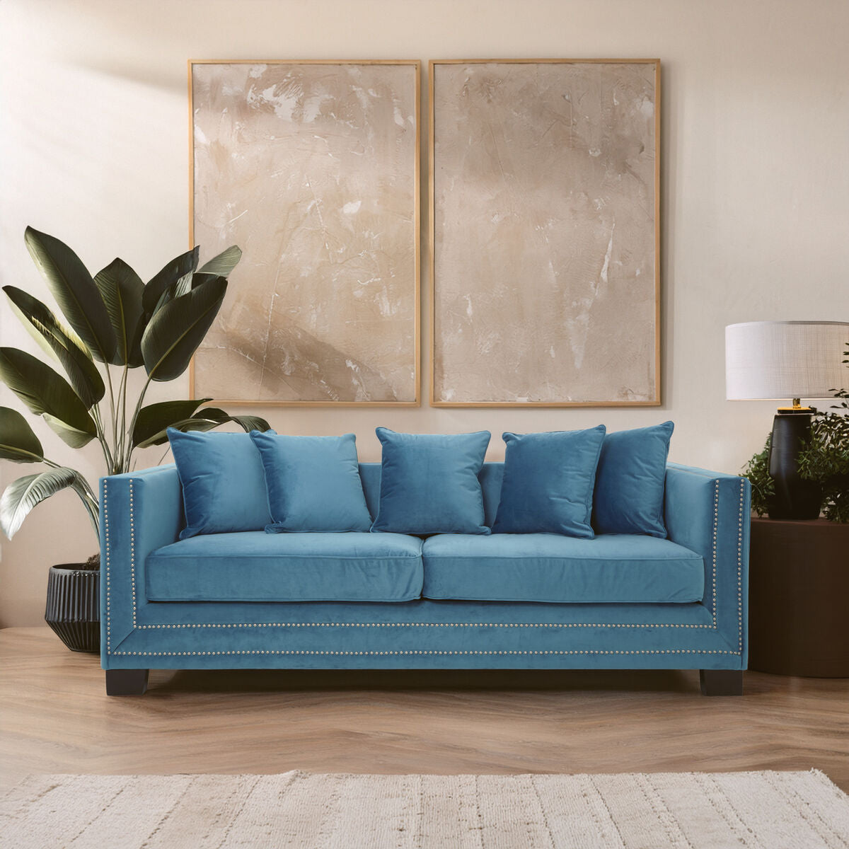Blue sofa in a living room with abstract art and plants