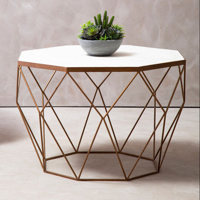 Hexagonal coffee table with geometric design and plant on a neutral background