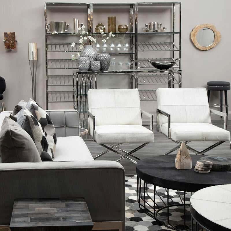 Modern living room with gray sofa, white chairs, and decorative items.