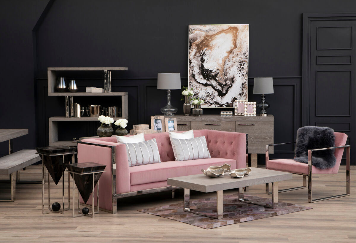 Modern living room with pink sofa, coffee table, and decorative items against a dark wall.