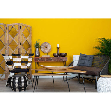 Modern living room with yellow wall, furniture, and decor items.
