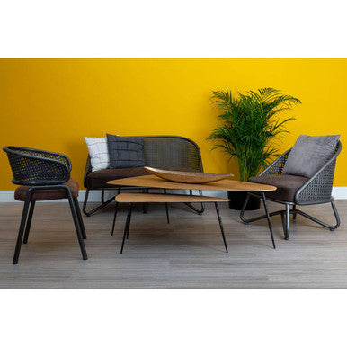 Outdoor furniture set with chairs, table, and plant against a yellow wall.