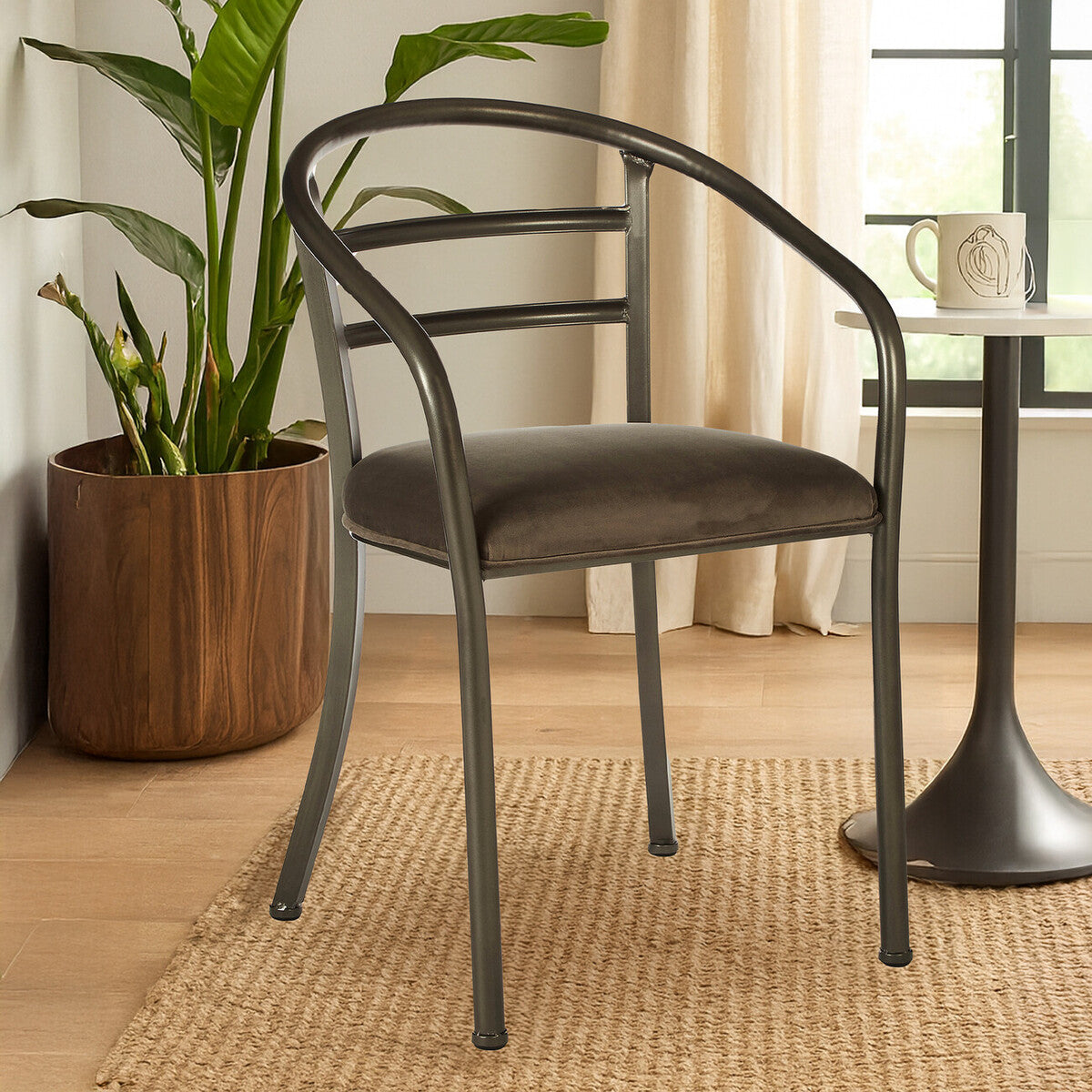 Gray chair in a room with a plant and small table