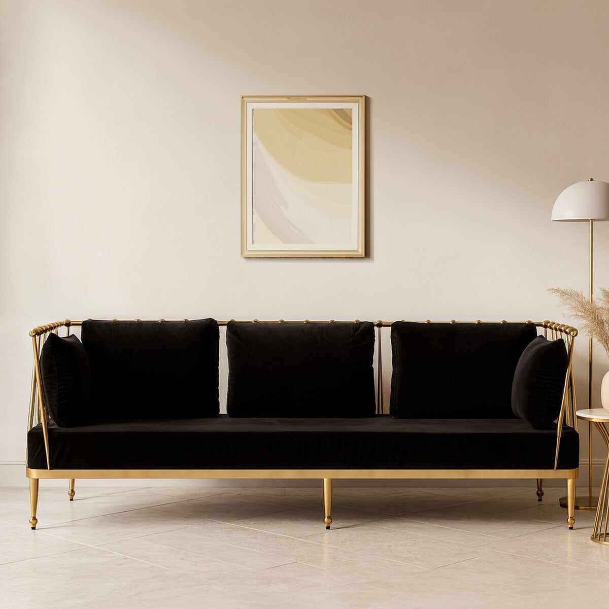 Black sofa with gold frame in a room with a painting and lamp.