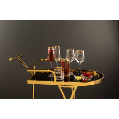 Gold serving tray with drinks and snacks on a dark background