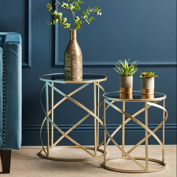 Blue armchair with gold side tables and decorative plants against a blue wall