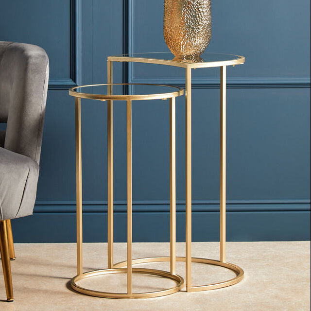 Gold side table with a vase of flowers against a blue wall