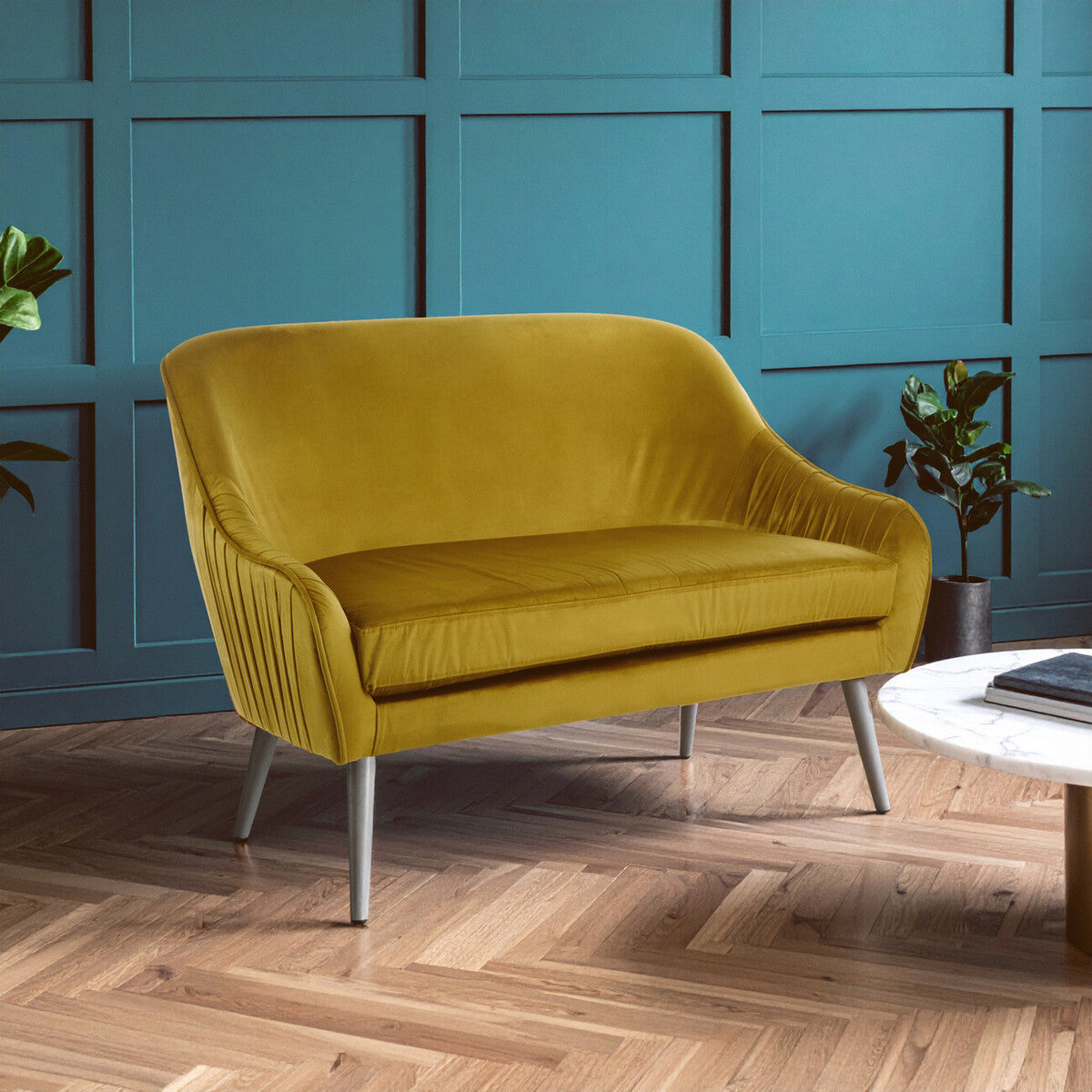 Yellow sofa in a room with blue paneled walls and wooden flooring.