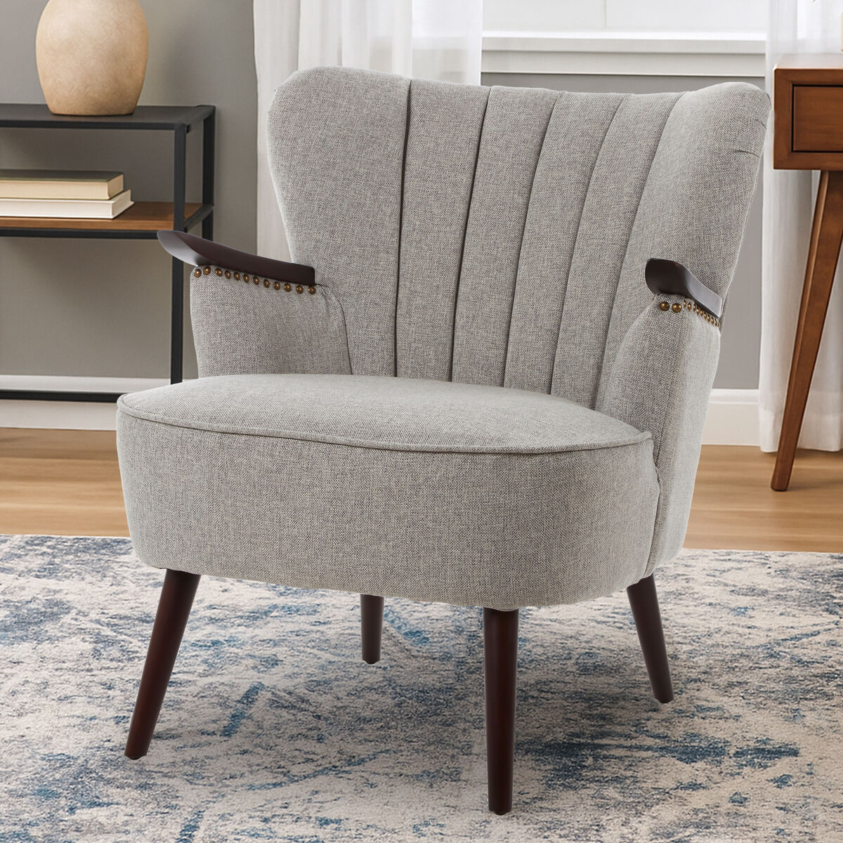 Gray upholstered armchair with wooden legs in a room setting.