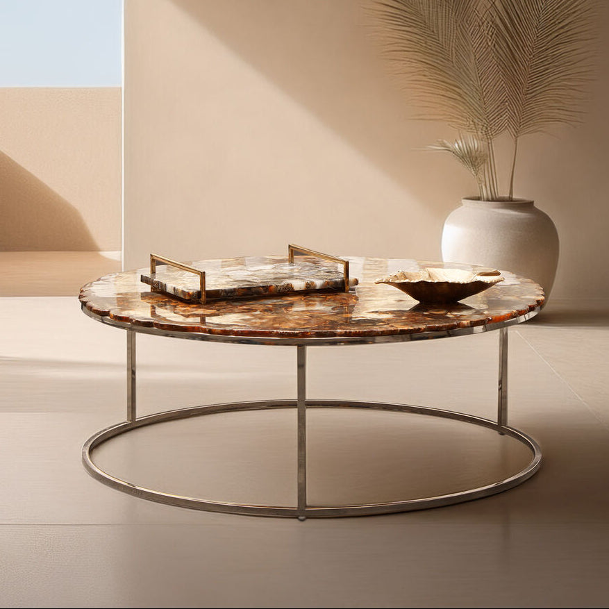 Modern round marble coffee table with decorative items in a minimalistic room.
