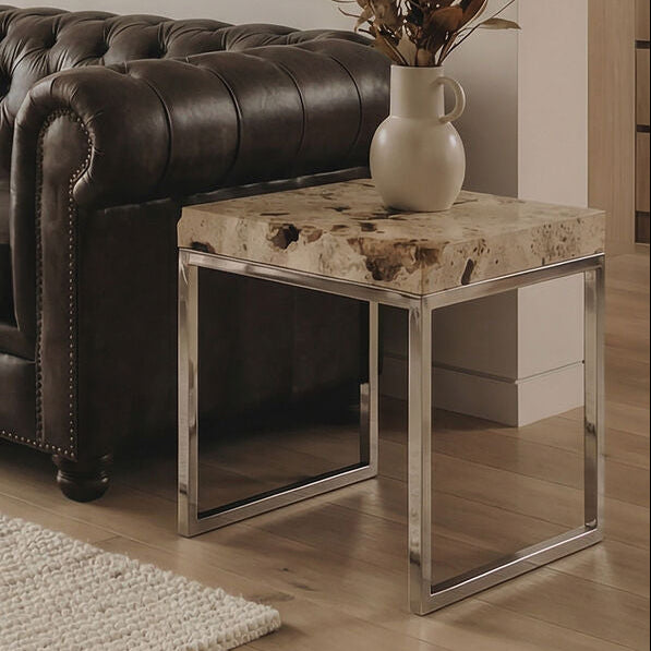 Living room with a brown leather sofa, abstract painting, and decorative table.