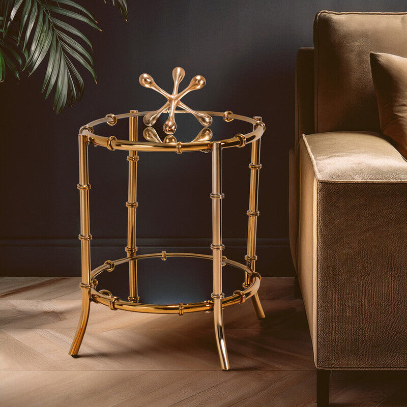 Gold side table with decorative top next to a brown sofa