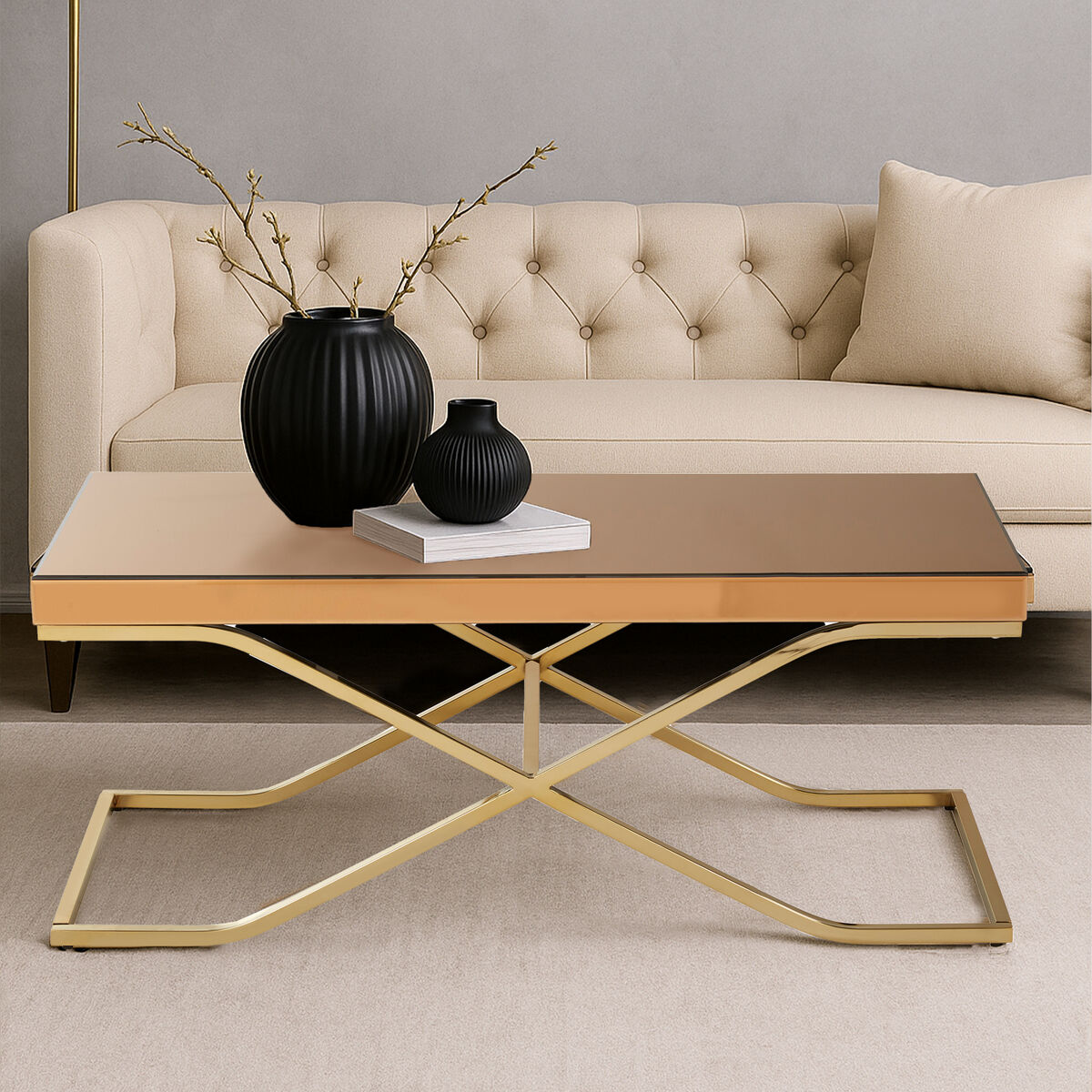 Beige sofa with a gold coffee table and black vases in a living room setting.