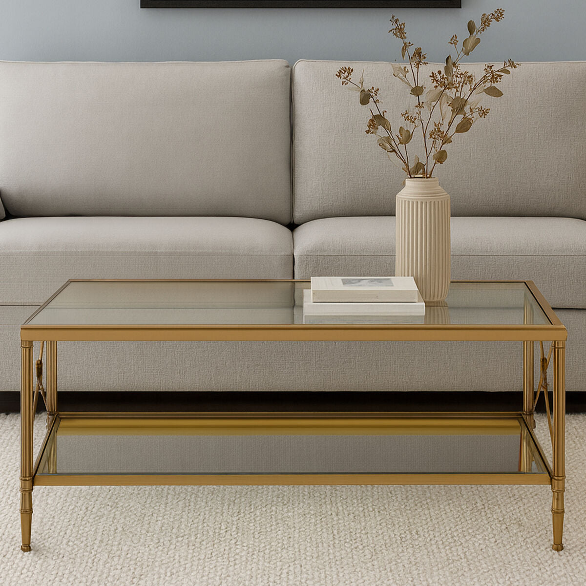 Glass coffee table with gold frame in front of a beige sofa