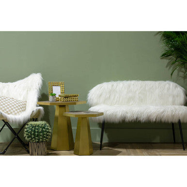 Modern interior with white fur chairs, a green table, and decorative items against a green wall.