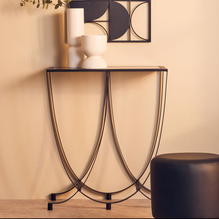 Modern console table with decorative items against a beige wall