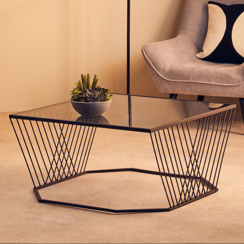 Modern living room with a glass coffee table, armchair, and floor lamp.