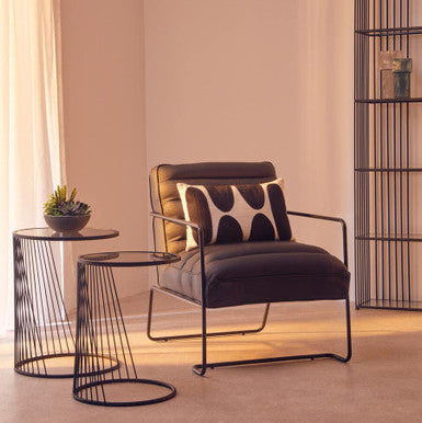 Modern armchair with a side table in a minimalistic room.