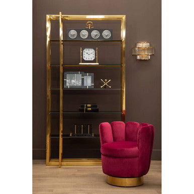 Gold display cabinet with decorative items and a red chair in a room.