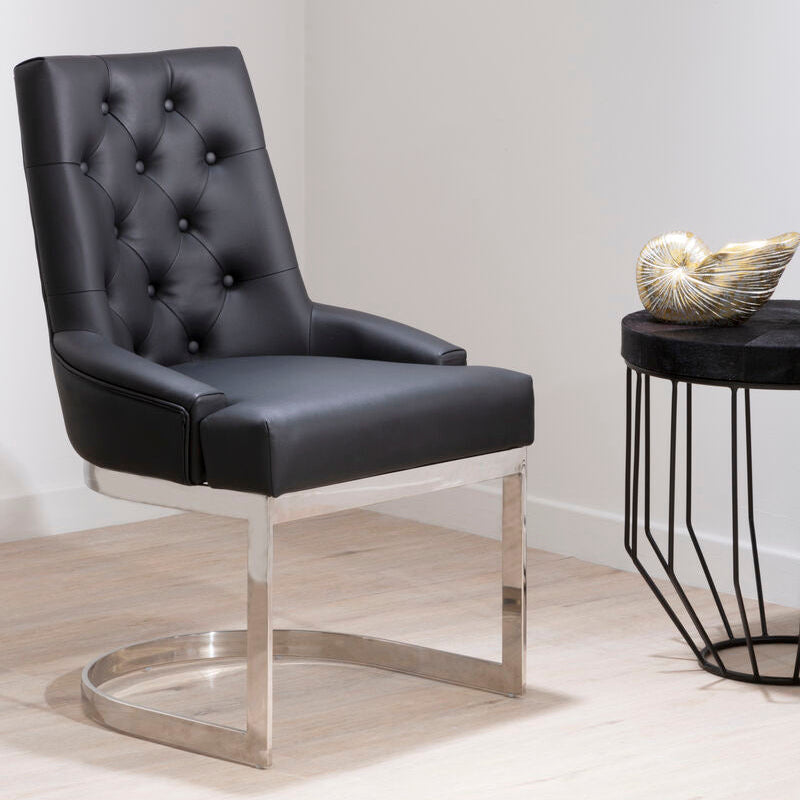 Black leather chair with metal legs in a minimalistic setting