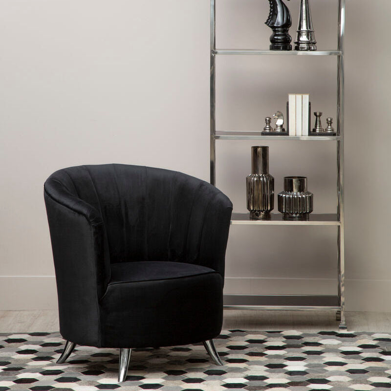 Black armchair in a room with a decorative shelf and patterned floor.