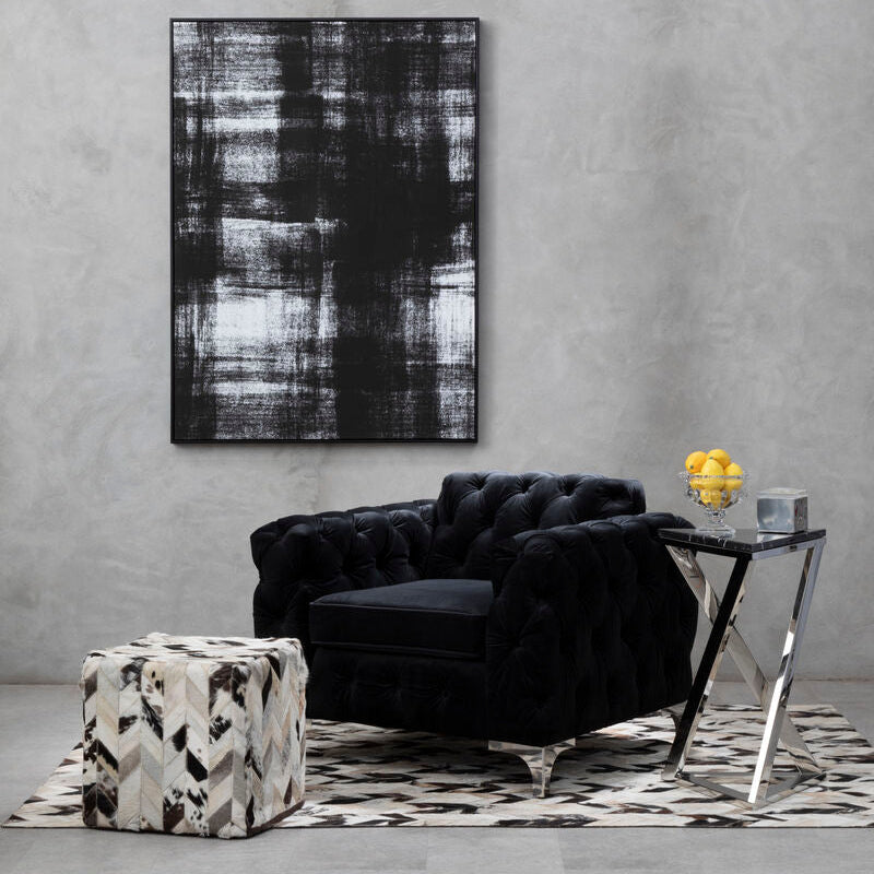Modern living room with a black armchair, abstract painting, and side table.