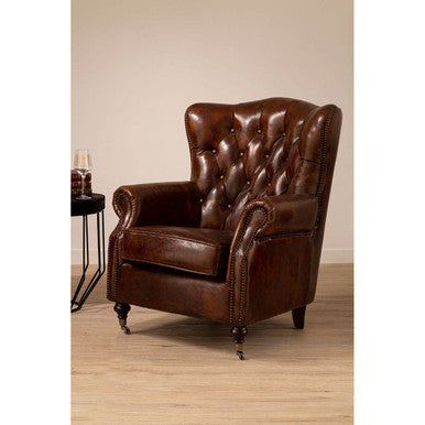 Brown leather armchair in a room with a side table.