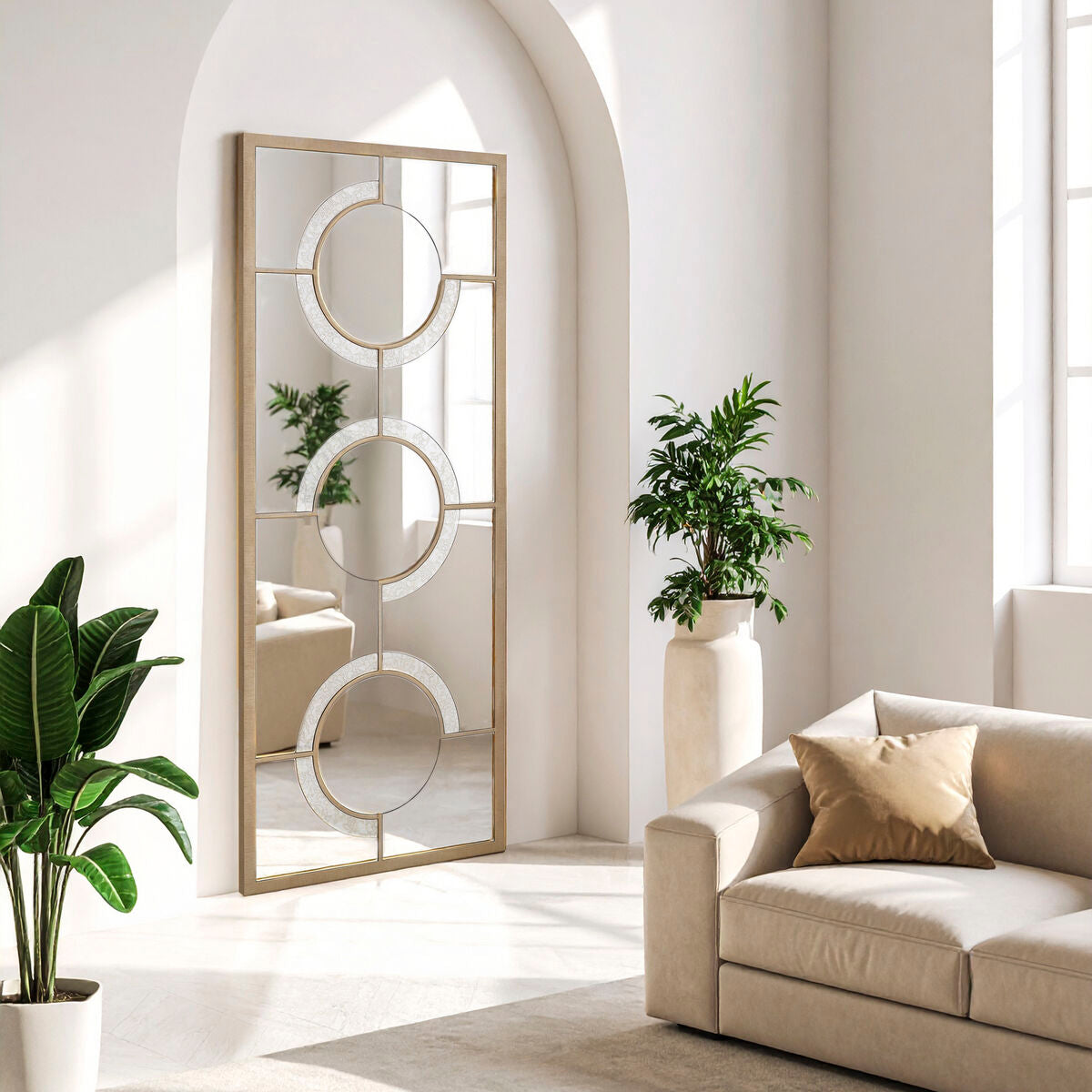 Modern living room with a decorative mirror, sofa, and plants.