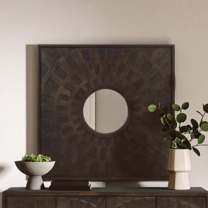 Dark wooden sideboard with decorative mirror above it in a room setting.
