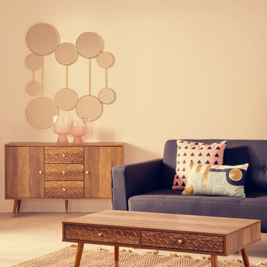 Living room with a wooden sideboard, coffee table, and blue sofa with decorative pillows.