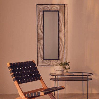 Modern chair with woven backrest in a room with a mirror and small table.