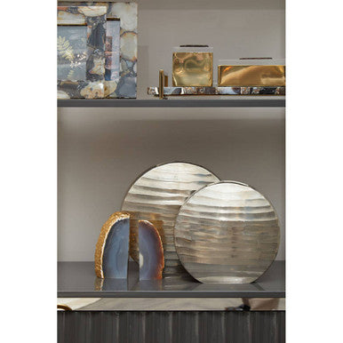 Decorative round objects on a shelf with abstract art in the background
