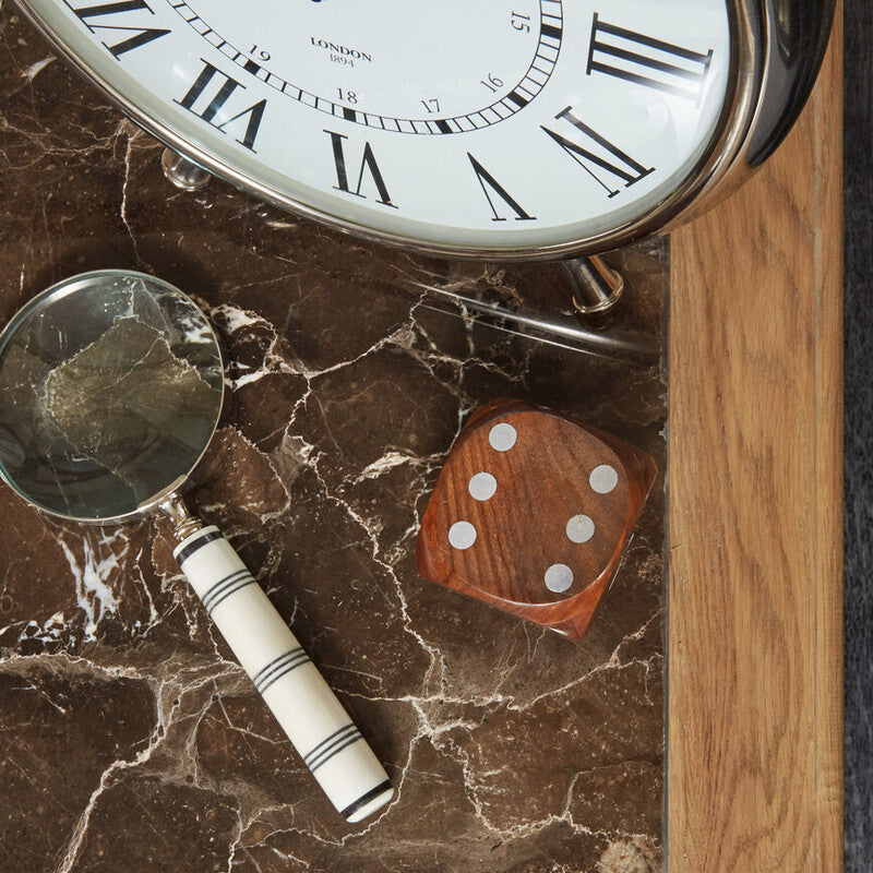 Clock, magnifying glass, and dice on a marble surface