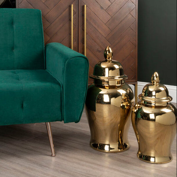 Modern interior with a green sofa, wooden cabinet, and decorative items.