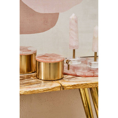 Decorative items on a wooden surface with pink and gold accents