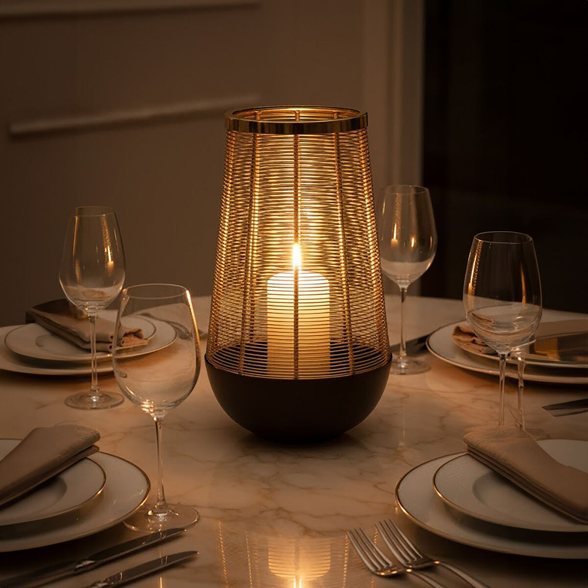 Decorative candle holder on a table with wine glasses and plates