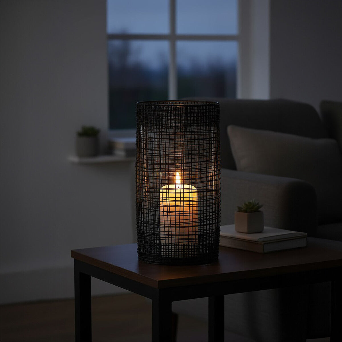 Candle in a woven holder on a wooden table in a dimly lit room.