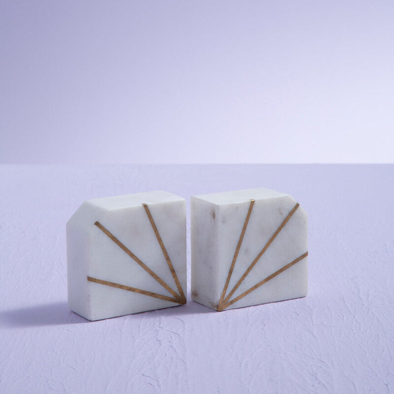 Two white marble blocks with gold accents on a light purple background